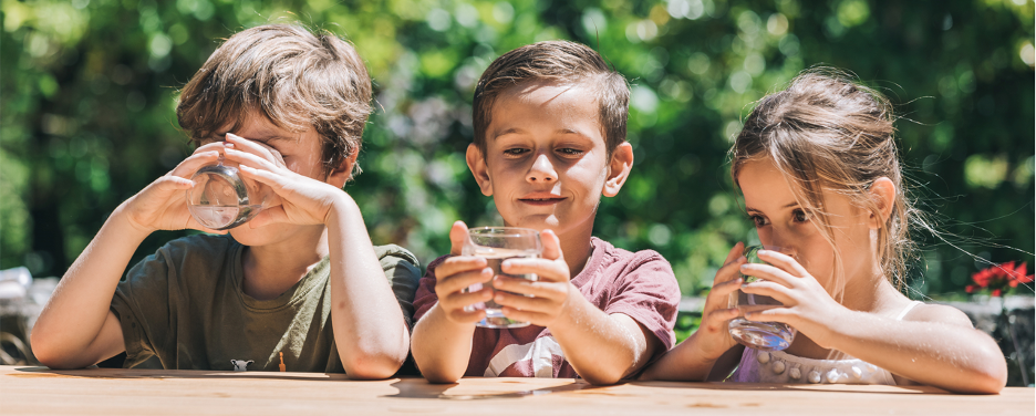 Three children drinking water